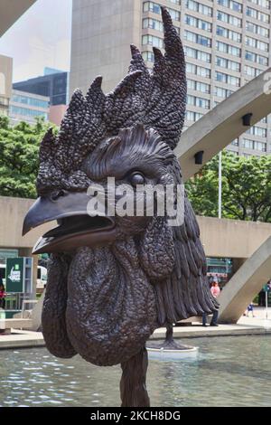 Les arches de la piscine réfléchissante de Nathan Phillips Square survolent les statues de la tête d'un coq devant l'ancien hôtel de ville dans le cadre de l'installation de sculpture d'ai Weiwei intitulée cercle des animaux (Zodiac chinois) à Toronto, Ontario, Canada, on 23 juin 2013. (Photo de Creative Touch Imaging Ltd./NurPhoto) Banque D'Images