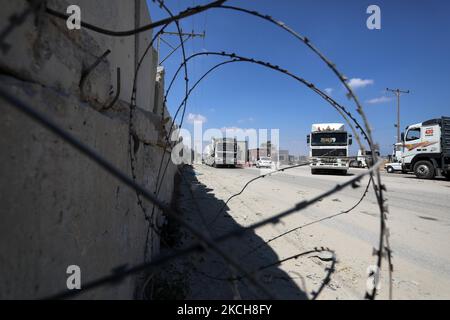 Des camions chargés de marchandises entrent dans la bande de Gaza depuis Israël par le passage de Kerem Shalom à Rafah, dans le sud de la bande de Gaza, sur 14 juillet 2021. Le directeur du poste frontière de Karem Abu Salem, Bassam Ghaben, a déclaré que les autorités israéliennes avaient annulé une décision récente interdisant l'entrée de marchandises dans la bande de Gaza. L'État d'occupation a autorisé l'entrée de toutes les marchandises, à l'exception des matériaux de construction. (Photo de Majdi Fathi/NurPhoto) Banque D'Images