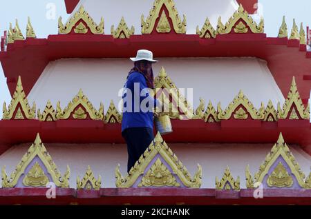 Un ouvrier peint sur un toit de crématoire lors de la réinnovation dans un temple de la province de Nonthaburi, à la périphérie de Bangkok sur 17 juillet 2021. (Photo de Chaiwat Subprasom/NurPhoto) Banque D'Images