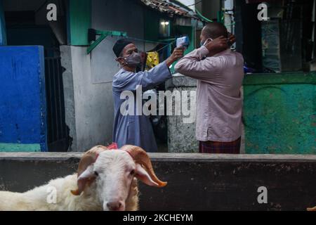 les musulmans indonésiens portant un masque de protection vérifient la température corporelle lorsqu'ils assistent à la prière d'Eid Al Adha lors des restrictions d'urgence de la COVID-19 le 20 juillet 2021 à Bandung, Indonésie. (Photo par Algi Febri Sugita/NurPhoto) Banque D'Images