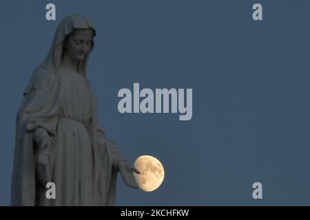 Vue sur la lune et la statue de la Vierge Marie près d'Arromanches. Mercredi, 20 juillet 2021, à Arromanches, Calvados, Normandie, France. (Photo par Artur Widak/NurPhoto) Banque D'Images