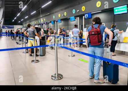 Personnes dans le hall des départs du nouveau T2 avec les comptoirs d'enregistrement à l'aéroport international de Thessalonique Makedonia SKG LGTS dans le nord de la Grèce. Passagers avec masque facial comme vu à l'intérieur et à l'extérieur du terminal de l'aéroport. Les passagers arrivant utilisent l'aéroport pour se rendre aux îles ou pour se rendre à des destinations de vacances proches comme Halkidiki, avec des tests PCR négatifs ou un passeport de vaccination verte. La Grèce est une destination de voyage populaire avec des plages célèbres et une industrie touristique fortement développée, avec une longue saison touristique car elle est située dans la partie sud de l'Europe dans les eaux méditerranéennes. GR Banque D'Images