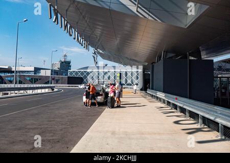 Personnes hors du hall des départs de T2 et de la Tour de contrôle visibles. Départs avec les comptoirs d'enregistrement à l'aéroport international de Thessalonique Makedonia SKG LGTS dans le nord de la Grèce. Passagers avec masque facial comme vu à l'intérieur et à l'extérieur du terminal de l'aéroport. Les passagers arrivant utilisent l'aéroport pour se rendre aux îles ou pour se rendre à des destinations de vacances proches comme Halkidiki, avec des tests PCR négatifs ou un passeport de vaccination verte. La Grèce est une destination de voyage populaire avec des plages célèbres et une industrie touristique fortement développée, avec une longue saison touristique comme il est situé dans la partie sud Banque D'Images