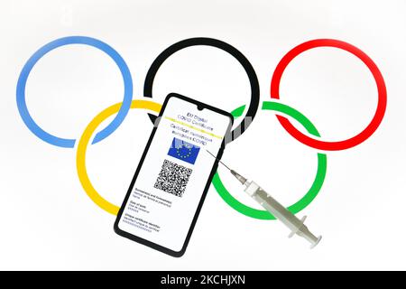 Le certificat COVID numérique de l'UE est affiché sur un écran de téléphone mobile photographié avec le fond du symbole des anneaux olympiques pour la photo d'illustration pendant la pandémie du coronavirus. Cracovie, Pologne sur 23 juillet 2021. (Photo de Beata Zawrzel/NurPhoto) Banque D'Images