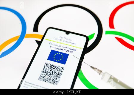 Le certificat COVID numérique de l'UE est affiché sur un écran de téléphone mobile photographié avec le fond du symbole des anneaux olympiques pour la photo d'illustration pendant la pandémie du coronavirus. Cracovie, Pologne sur 23 juillet 2021. (Photo de Beata Zawrzel/NurPhoto) Banque D'Images