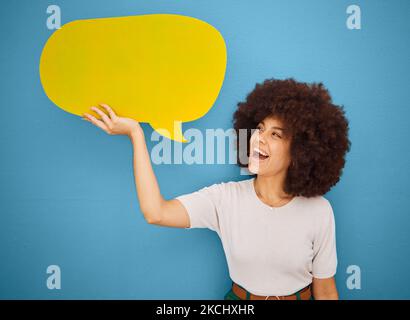 Femme noire avec bulle de parole jaune, afro et fond bleu maquette espace pour la publicité ou le placement de produit. Sourire, signe d'annonce et femme Banque D'Images