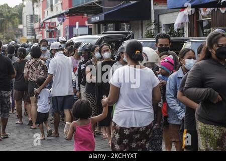 Les personnes portant un masque de protection s'alignent sur la nourriture gratuite donnée aux citoyens touchés par la restriction pandémique COVID-19 à Kuta, Bali, Indonésie sur 30 juillet 2021. Le gouvernement indonésien impose des restrictions d'urgence à la communauté afin de freiner l'augmentation des infections à COVID-19 dans tout le pays jusqu'à 2 août 2021. L'Indonésie est devenue le nouvel épicentre de la COVID-19 avec plus de 2 millions de cas enregistrés et 80 000 décès depuis le début de la pandémie. (Photo de Johannes Christo/NurPhoto) Banque D'Images