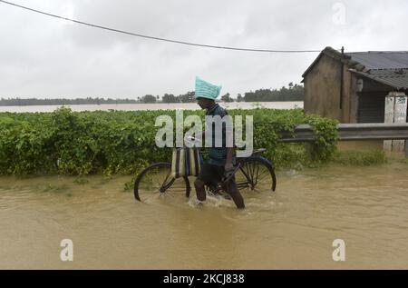 Un villageois à vélo se démène dans une rue inondée d'Udaynarayanpur, dans le district de Howrah au Bengale occidental, Inde, le 04 août 2021. (Photo par Indranil Aditya/NurPhoto) Banque D'Images