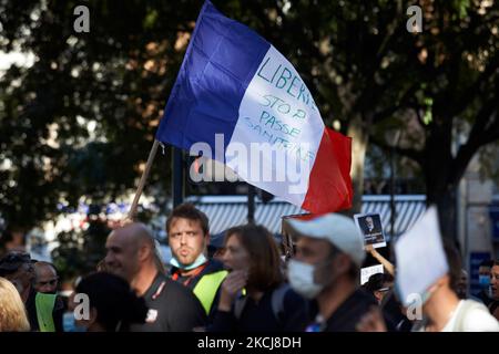 Un homme porte un drapeau français portant la mention « Liberty: Stop to the Health Pass ». Des centaines de manifestants sont descendus dans la rue à Toulouse contre la vaccination presque obligatoire et contre le pass sanitaire après le discours de Macron sur 12 juillet. Ils ont protesté d'envoyer un message au Conseil constitutionnel qui prendra position sur la constitutionnalité de la carte santé Covid-19 sur 5 août. Sur 12 juillet, Macron a annoncé que la carte santé sera obligatoire pour se rendre dans les lieux publics tels que les cafés, les théates, la salle de concerts, les cinémas, les centres commerciaux, les transports en commun, les piscines publiques, et même h Banque D'Images