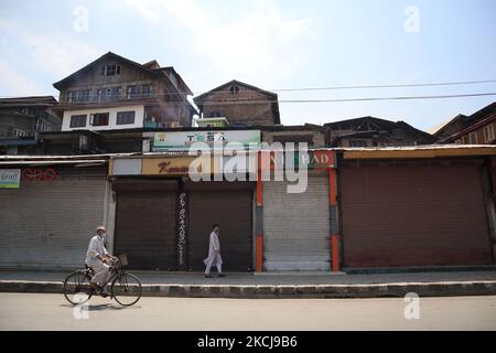 Un cachemiri passe devant les magasins fermés lors de la fermeture à l'occasion de l'anniversaire de la révocation de l'article 370 à Srinagar, dans le Cachemire administré par l'Inde, le 05 août 2021. Selon les rapports, un souffle de faible intensité a eu lieu à l'extérieur de la grande mosquée du Cachemire Jamia Masjid, suivi de coups de feu. La plupart des établissements commerciaux sont restés fermés, tandis que certains des commerçants ont prétendu que la police indienne les obligerait à ouvrir des magasins contre leur volonté. (Photo de Muzamil Mattoo/NurPhoto) Banque D'Images