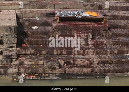 Le corps sur une civière qui attend d'être incinéré repose le long des marches menant à la rive de la rivière Bagmati aux ghats de crémation de Pashupatinath à Katmandou, au Népal, sur 10 décembre 2011. Selon la religion et les traditions hindoues, les morts doivent être incinérés. Les corps sont incinérés selon la coutume et les cendres et les restes sont emportés dans les eaux saintes. Le Bagmati court dans le Gange plus au sud et est considéré comme tout aussi Saint pour les Hindous. Le complexe de Pashupatinath est le plus sacré site hindou du Népal. (Photo de Creative Touch Imaging Ltd./NurPhoto) Banque D'Images