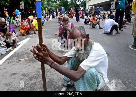 Les pauvres font la queue et attendent de recevoir de la nourriture de la police métropolitaine de Dhaka pendant le confinement imposé pour contenir la propagation du coronavirus Covid-19 dans la région de Poribag à Dhaka, au Bangladesh, sur 8 août 2021 (photo de Mamunur Rashid/NurPhoto) Banque D'Images