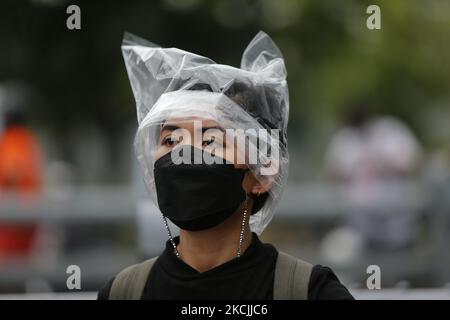 Les manifestants couvrent sa tête par un sac en plastique lors de la manifestation à Bangkok sur 13 août 2021. La police de Bangkok a tiré des balles en caoutchouc et des gaz lacrymogènes contre des manifestants pro-démocratie qui ont demandé le départ du Premier ministre, le président Prayut Chan-o-cha et le gouvernement a été tenu pour responsable de sa mauvaise gestion grossière de la pandémie de Covid-19. (Photo de Chaiwat Subprasom/NurPhoto) (photo de Chaiwat Subprasom/NurPhoto) Banque D'Images