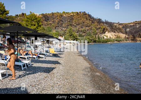 Plage de Kohili près de Limni avec la pente brûlée et la forêt en arrière-plan. Les séquelles des incendies en Grèce, alors que de petites flammes continuent de brûler dans la forêt. Une énorme catastrophe environnementale a eu lieu en Grèce. Forêt, pins, oliveraies, entreprises, hôtels, des maisons, des véhicules et des animaux ont été brûlés. L'incendie s'est terminé après une pluie nocturne, alors que les jours précédents les pompiers grecs, les volontaires locaux, les pompiers étrangers, les avions et les hélicoptères où se battaient pour éteindre le feu de forêt dans l'île grecque d'Evia (Euboea) - près de 100 000 hectares de forêts et de terres agricoles ha Banque D'Images