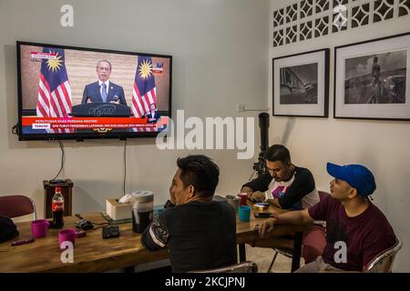 Les gens regardent une retransmission en direct du Premier ministre malaisien Muhyiddin Yassin annonçant sa démission après avoir perdu sa majorité au Parlement de Kuala Lumpur sur 16 août 2021. (Photo de Mohd Firdaus/NurPhoto) Banque D'Images