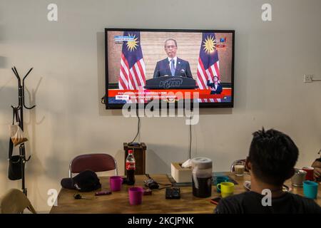 Les gens regardent une retransmission en direct du Premier ministre malaisien Muhyiddin Yassin annonçant sa démission après avoir perdu sa majorité au Parlement de Kuala Lumpur sur 16 août 2021. (Photo de Mohd Firdaus/NurPhoto) Banque D'Images