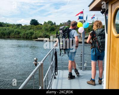 Deux marcheurs sont sur un ferry traversant la rivière pour continuer à marcher sur la nouvelle route, le sentier de montagne hollandais autour du sud de Limbourg, aux pays-Bas, sur 13 août 2021. (Photo par Romy Arroyo Fernandez/NurPhoto) Banque D'Images