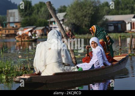Les femmes musulmanes cachemiri font un ferry pour une fille d'école le long du célèbre lac Dal du Cachemire vers une petite école à Srinagar, au Cachemire, en Inde, sur 26 juin 2010. (Photo de Creative Touch Imaging Ltd./NurPhoto) Banque D'Images