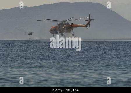 Un hélicoptère de pompier a été révélé avec de l'eau lors d'un incendie de forêt dans la région de Villia, au nord-ouest d'Athènes, Grèce, le 17 août 2021. (Photo par Dimitris Lampropoulos/NurPhoto) Banque D'Images