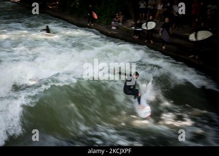 Les gens au jardin anglais, sur la 15 août ,2021 à Munich, Allemagne. L'Eisbach est une rivière artificielle de Munich, qui coule également pendant une longue période à travers le parc Englischer Garten. Cette rivière est particulièrement bien connue pour son afflux de surfeurs, qui profitent de la vague debout pour s'amuser chaque mois de l'année. (Photo par Andrea Ronchini/NurPhoto) Banque D'Images