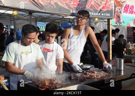 Les vendeurs de produits alimentaires ont barbecue des calmars sur un bâton pendant un marché chinois de nuit à Markham, Ontario, Canada, on 24 juillet 2015. (Photo de Creative Touch Imaging Ltd./NurPhoto) Banque D'Images