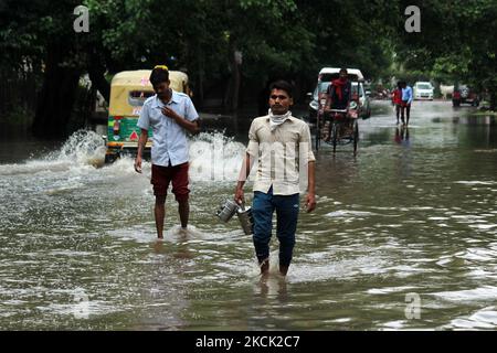 Des hommes traversent une rue inondée après de fortes pluies à Ghaziabad, une banlieue de New Delhi, en Inde, sur 21 août 2021. Samedi, des pluies intenses ont écrasé la capitale nationale, paralysant le mouvement de la circulation et causant de fortes averses d'eau dans de nombreuses parties de la ville. (Photo de Mayank Makhija/NurPhoto) Banque D'Images