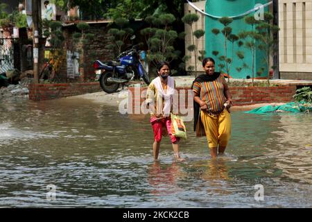 Les femmes traversent une rue inondée après de fortes pluies à Ghaziabad, une banlieue de New Delhi, en Inde, sur 21 août 2021. Samedi, des pluies intenses ont écrasé la capitale nationale, paralysant le mouvement de la circulation et causant de fortes averses d'eau dans de nombreuses parties de la ville. (Photo de Mayank Makhija/NurPhoto) Banque D'Images