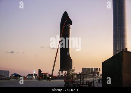 Après avoir entièrement empilé Starship et Super Heavy Booster, ce qui a permis de créer le plus grand engin spatial jamais fabriqué, SpaceX a fait remonter le booster à High Bay pour les essais finaux tandis que Starship SN20 reste sur le site de lancement pour les essais finaux et l'application de tuiles de résistance à la chaleur pour son retour dans l'atmosphère après le lancement. La tour de lancement orbitale est maintenant entièrement empilée et attend les bras en mode reflex que SpaceX prévoit d'attacher dans les prochains jours. SN15 et SN16 sont assis derrière le site de construction et la tour de lancement orbitale attend la fixation de ses bras en mode reflex dans les quelques prochaines Banque D'Images