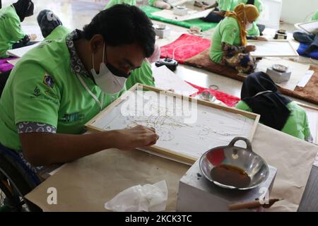 Les personnes handicapées sont formées à batik dans le hall du bâtiment Balai Pustaka, Palmeriam, Mattaman, Djakarta est, Indonésie sur 24 août 2021. Dans l'activité, les participants ont appris à faire du batik avec le canting. Ils ont fait plusieurs photos comme des mascottes de forage à l'huile et des engins de forage, ondel-ondel, Monas et ainsi de suite. Tous les participants sont des résidents et des étudiants du district de Matraman qui ont des besoins spéciaux. L'événement est prévu pour durer jusqu'à mercredi. Toutefois, si possible, elle sera maintenue pendant 24 jours. (Photo de Dasril Roszandi/NurPhoto) Banque D'Images