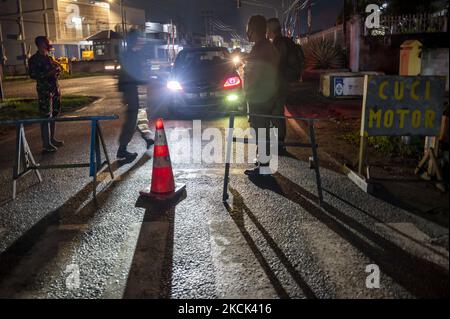 Les officiers sont garde à l'entrée d'un complexe de logements où une microserrure efficace est appliquée dans le village de Birobuli Sud, ville de Palu, province centrale de Sulawesi, Indonésie sur 23 août 2021. Le gouvernement local a mis en place Lock micro effective (LME) dans plusieurs villages urbains de la ville afin de réduire la transmission de COVID -19 qui continue d'augmenter à plus de 200 pour cent au cours du mois d'août. Ce verrouillage inclut l'interdiction d'entrer et de sortir du complexe et doit montrer les résultats d'un test d'antigène rapide. Les besoins en nourriture et en boissons des résidents touchés par la politique sont en effet du bor Banque D'Images