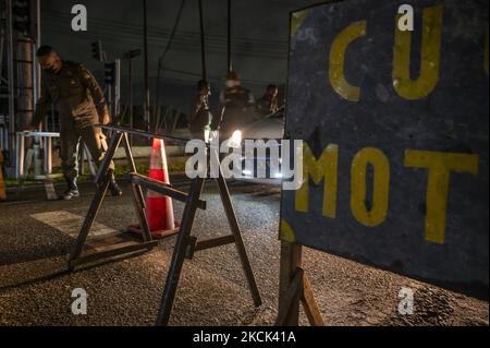 Les officiers sont garde à l'entrée d'un complexe de logements où une microserrure efficace est appliquée dans le village de Birobuli Sud, ville de Palu, province centrale de Sulawesi, Indonésie sur 23 août 2021. Le gouvernement local a mis en place Lock micro effective (LME) dans plusieurs villages urbains de la ville afin de réduire la transmission de COVID -19 qui continue d'augmenter à plus de 200 pour cent au cours du mois d'août. Ce verrouillage inclut l'interdiction d'entrer et de sortir du complexe et doit montrer les résultats d'un test d'antigène rapide. Les besoins en nourriture et en boissons des résidents touchés par la politique sont en effet du bor Banque D'Images