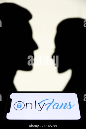 Le logo OnlyFans affiché sur un écran de téléphone est vu avec des silhouettes en papier qui ressemblent à un homme et une femme en arrière-plan dans cette photo d'illustration prise à Cracovie, Pologne sur 25 août 2021. (Photo de Jakub Porzycki/NurPhoto) Banque D'Images