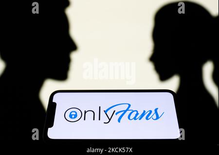 Le logo OnlyFans affiché sur un écran de téléphone est vu avec des silhouettes en papier qui ressemblent à un homme et une femme en arrière-plan dans cette photo d'illustration prise à Cracovie, Pologne sur 25 août 2021. (Photo de Jakub Porzycki/NurPhoto) Banque D'Images