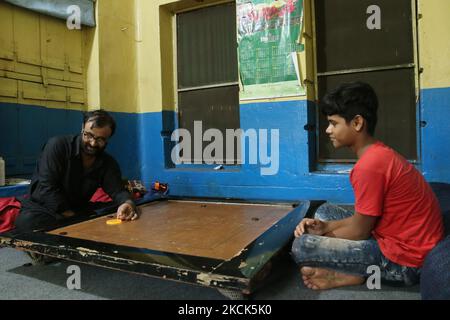 Hommes d'origine afghane résidant en Inde jouant du carrom avec le garçon indien près de Kolkata un vieux tenent d'origine afghane résidant en Inde sur 25 août,2021. (Photo de Debajyoti Chakraborty/NurPhoto) Banque D'Images