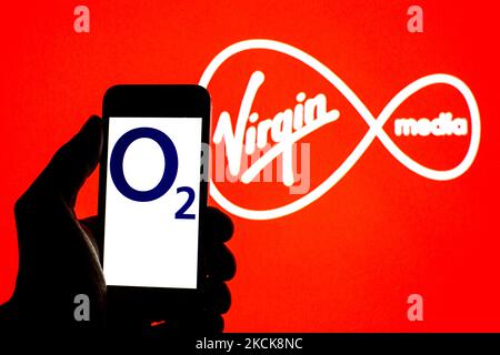 Sur cette photo, un logo O2 apparaît sur un smartphone avec un logo Virgin Media Inc en arrière-plan. (Photo par DAX Images/NurPhoto) Banque D'Images