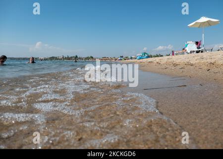 La vie quotidienne à la plage avec des touristes, principalement des Balkans et des habitants appréciant le soleil, la mer, la plage de Nea Iraklia ou Paralia Irakleia dans la région de Halkidiki. La plage de sable avec l'eau de mer transparente cristal a de nombreux bars de plage, offrant des parasols et des chaises longues, l'ombre et les boissons froides tandis que les amateurs de plage sont vus nager, bains de soleil, détente, appréciant la mer. Les gens apprécient l'eau sur la rive, comme l'un des derniers week-ends de la saison estivale. La Grèce est largement tributaire du secteur du tourisme, une industrie sur laquelle la pandémie du coronavirus Covid-19 a eu un effet spectaculaire. Le bea Banque D'Images