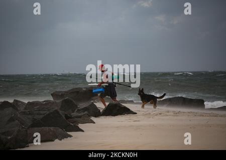 Un homme et son chien quittent une plage alors que des vestiges de l'Ida Hurrican frappent Cape May point, dans le New Jersey, la pointe la plus méridionale de l'État sur 1 septembre 2021 (photo de Bryan Olin Dozier/NurPhoto) Banque D'Images