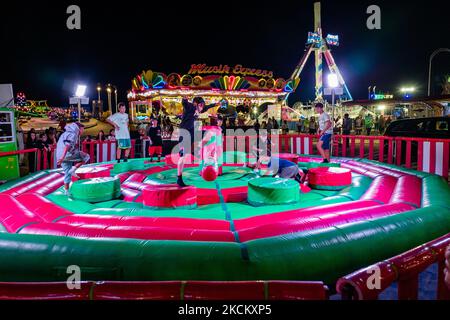 Les garçons ont du plaisir à sauter sur l'obstacle tournant le premier jour de l'ouverture du Luna Park à Molfetta le 4 septembre 2021. A l'occasion de la Fête Patronale de Molfetta et en l'honneur de la Madonna dei Martiri, le Luna Park a été ouvert à la Secca dei Pali, avec des portes d'accès et de sortie, le contrôle de la température d'accès et le contrôle aléatoire des passes vertes selon les instructions de la loi. (Photo par Davide Pischettola/NurPhoto) Banque D'Images