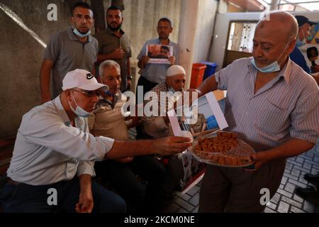 Un palestinien passe des bonbons dans la ville de Gaza, sur 6 septembre 2021, après que six prisonniers palestiniens se sont échappés de la prison de Gilboa, dans le nord d'Israël, le lundi 6 septembre 2021. Les forces israéliennes ont lancé lundi une chasse massive à l'homme dans le nord d'Israël et en Cisjordanie occupée après que les prisonniers aient échappé de nuit de l'installation de haute sécurité dans un quartier extrêmement rare. (Photo de Majdi Fathi/NurPhoto) Banque D'Images