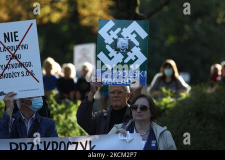 Un homme porte un signe avec une photo du leader polonais de facto Jaroslaw Kaczynski avec les logos de l'ultranationaliste, le camp radical national d'extrême-droite (ONR) devant le Parlement à Varsovie, en Pologne, le 6 septembre 2021. Plusieurs centaines de manifestants se sont rassemblés devant le Sejm, le Parlement polonais, pour protester contre un décret présidentiel qui a invoqué l'état d'urgence le long de la région frontalière avec le Bélarus. Alors que ses partisans soutiennent que la Pologne est menacée par une guerre hybride menée par le Belarus, qui pousse les migrants du Moyen-Orient au-dessus des frontières, les opposants soutiennent que la loi est un outil politique qui en résulte Banque D'Images