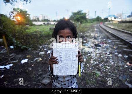 Une fille de taudis tient sa copie où elle a écrit des mots anglais de base comme sa leçon lors d'une classe privée prise par une police de Kolkata le jour de la Journée internationale de l'alphabétisation à Kolkata, Inde, 08 septembre 2021. (Photo par Indranil Aditya/NurPhoto) Banque D'Images