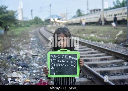 Une fille de taudis tient son tableau d'ardoise où elle écrit des alphabets anglais de base comme sa leçon lors d'une classe privée prise par une police de Kolkata le jour de la Journée internationale de l'alphabétisation à Kolkata, Inde, 08 septembre 2021. (Photo par Indranil Aditya/NurPhoto) Banque D'Images