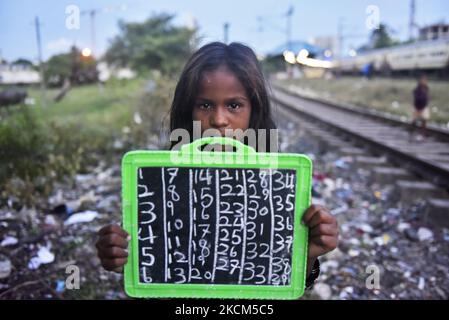 Une fille de taudis tient son tableau d'ardoise où elle écrit des chiffres de base comme sa leçon lors d'une classe privée prise par une police de Kolkata le jour de la Journée internationale de l'alphabétisation à Kolkata, Inde, 08 septembre 2021. (Photo par Indranil Aditya/NurPhoto) Banque D'Images