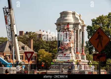 Les troopistes d'État observent alors que les travailleurs ont vu la statue du général confédéré Robert E. Lee en deux parties pour le transport après son enlèvement. La Cour suprême de Virginie a décidé la semaine dernière que le monument de six étages pouvait être enlevé. Il reste encore à déterminer si le piédestal couvert par les graffitis anti-racisme sera enlevé compte tenu de son rôle prépondérant dans le soulèvement anti-racisme de 2020 à Richmond. (Photo d'Allison Bailey/NurPhoto) Banque D'Images