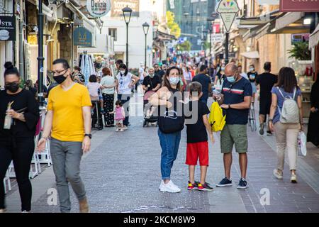 Les habitants et les touristes sont vus avec facemask à pied à la promenade du front de mer de l'ancien port vénitien de la ville de Chania avec les petites boutiques, tavernes, cafés et restaurants autour ainsi que le célèbre phare, la mosquée, les chantiers navals vénitiens et les monuments anciens et les monuments près du port et de la mer Égée. La Grèce tente de stimuler son tourisme et de donner des privilèges pour se faire vacciner contre la pandémie du coronavirus Covid-19, les touristes internationaux et les habitants, car le pays est fortement tributaire de l'industrie du tourisme et des voyages malgré le nombre inquiétant de cas avec le Coro Covid-19 Banque D'Images