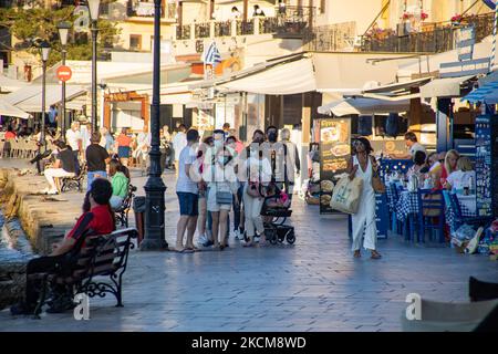 Les habitants et les touristes sont vus avec facemask à pied à la promenade du front de mer de l'ancien port vénitien de la ville de Chania avec les petites boutiques, tavernes, cafés et restaurants autour ainsi que le célèbre phare, la mosquée, les chantiers navals vénitiens et les monuments anciens et les monuments près du port et de la mer Égée. La Grèce tente de stimuler son tourisme et de donner des privilèges pour se faire vacciner contre la pandémie du coronavirus Covid-19, les touristes internationaux et les habitants, car le pays est fortement tributaire de l'industrie du tourisme et des voyages malgré le nombre inquiétant de cas avec le Coro Covid-19 Banque D'Images