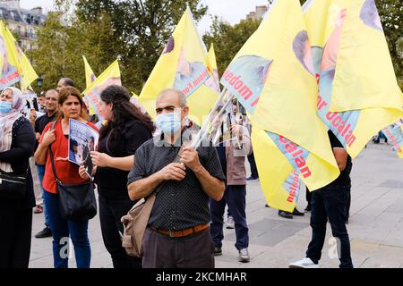 Ce manifestant kurde détient des drapeaux portant l'effigie d'Abdullah Öcalan. A Paris, en France, sur 11 septembre 2021 comme dans de nombreuses villes d'Europe, la diaspora kurde a manifesté pour la libération du philosophe et fondateur du PKK. Abdullah Öcalan emprisonné depuis 1999 sur l'île d'Imrali, est une figure fédératrice pour de nombreux Kurdes de différents mouvements politiques. (Photo de Vincent Koebel/NurPhoto) Banque D'Images