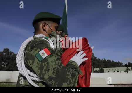 Les membres du Secrétariat de la Défense nationale (SEDENA) abaissent le drapeau mexicain sur l'esplanade de l'usine de vêtements et d'équipements El Vergel Iztapalapa, à Mexico, lors de l'urgence sanitaire COVID-19 et du feu de circulation épidémiologique jaune dans la capitale. (Photo de Gerardo Vieyra/NurPhoto) Banque D'Images