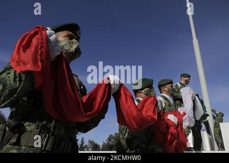 Les membres du Secrétariat de la Défense nationale (SEDENA) abaissent le drapeau mexicain sur l'esplanade de l'usine de vêtements et d'équipements El Vergel Iztapalapa, à Mexico, lors de l'urgence sanitaire COVID-19 et du feu de circulation épidémiologique jaune dans la capitale. (Photo de Gerardo Vieyra/NurPhoto) Banque D'Images