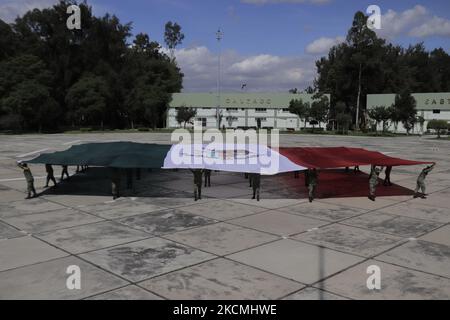 Membres du Secrétariat de la Défense nationale (SEDENA) sur l'esplanade de l'usine de vêtements et d'équipements El Vergel Iztapalapa, Mexico, Étaler un drapeau monumental dessiné et peint sur un tissu de nylon de haute qualité pour marquer le Grito de Independencia et la parade militaire qui se tiendra les 15 et 16 septembre pendant l'urgence sanitaire due à COVID-19 et le feu jaune de circulation épidémiologique dans la capitale. (Photo de Gerardo Vieyra/NurPhoto) Banque D'Images